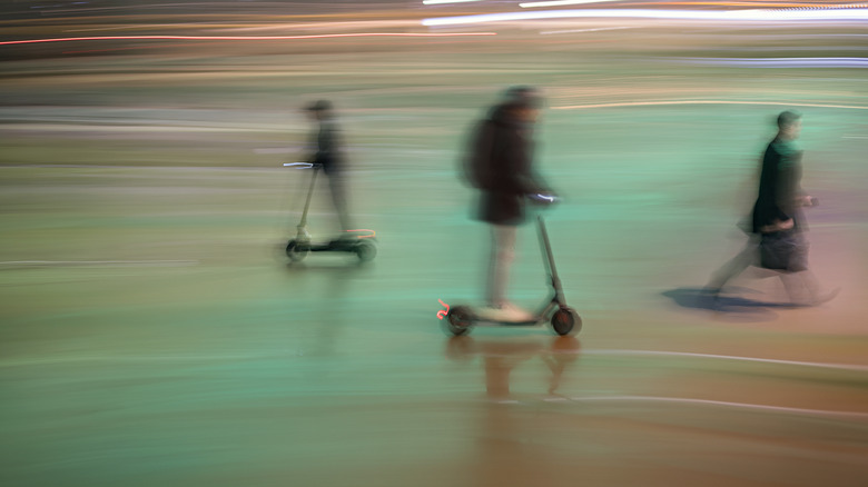 long exposure shot of people riding scooters