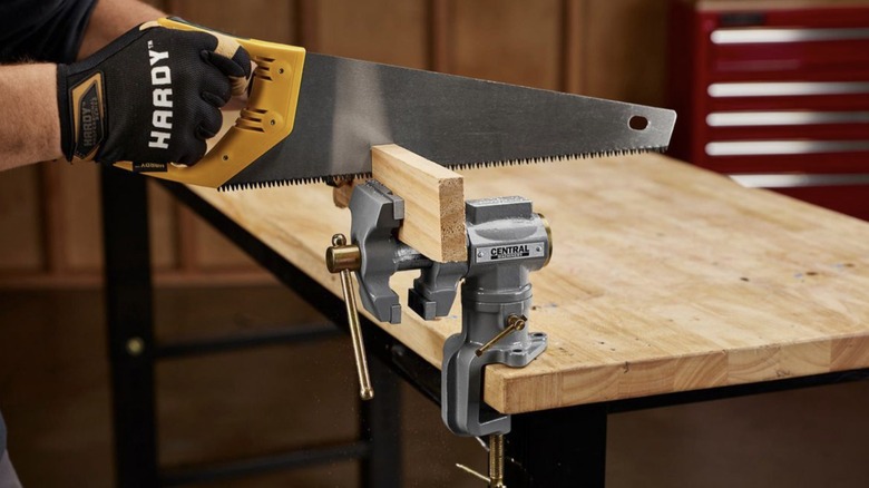 sawing wood in vise