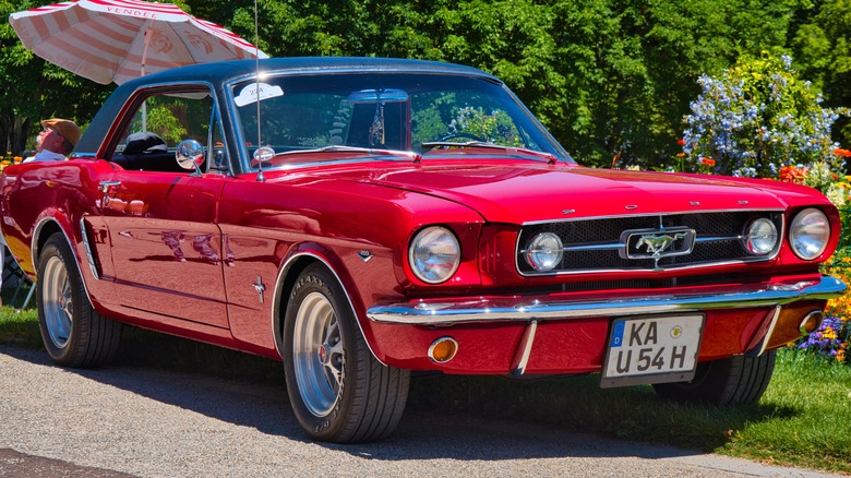 First-generation Ford Mustang red parked grass