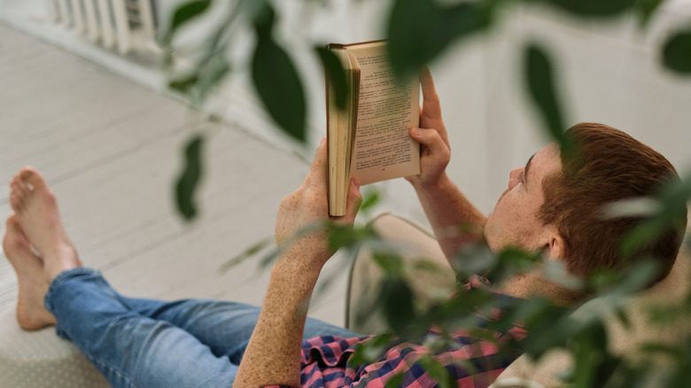 Man reading a book while sitting on a chair