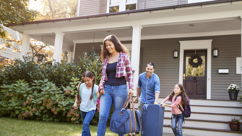 Family going out of the house with luggage