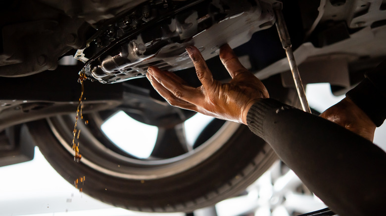 mechanic draining transmission fluid