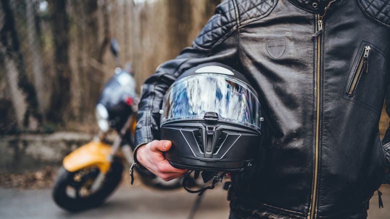 Motorcyclist holding helmet