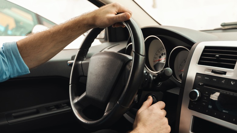 Man turning ignition switch car