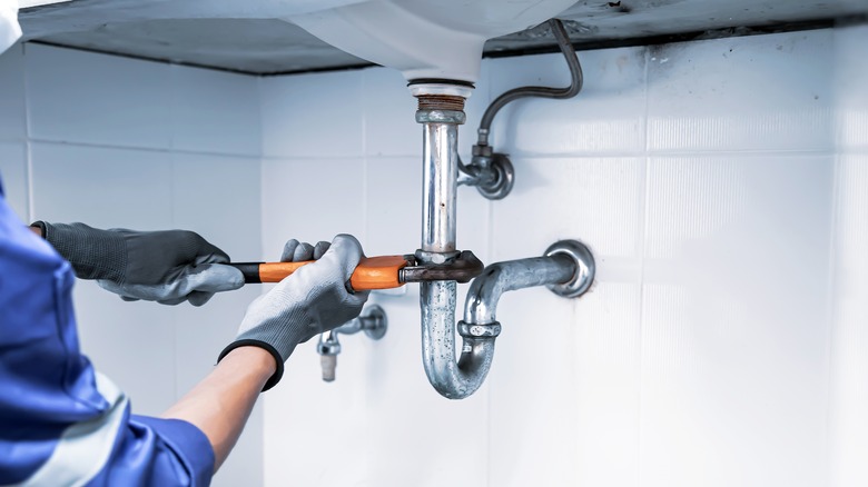 plumber working on sink