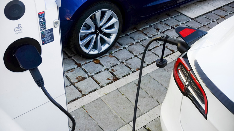 Tesla model 3 plugged into charging station