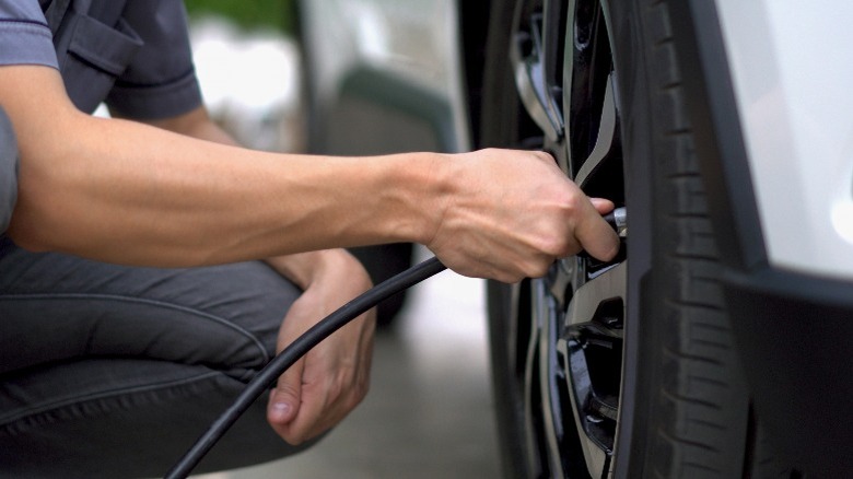 A man pumping a car tire