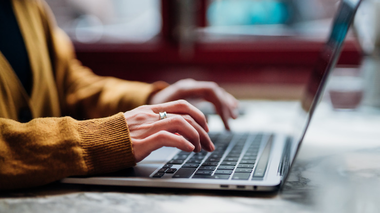 woman typing on laptop keyboard