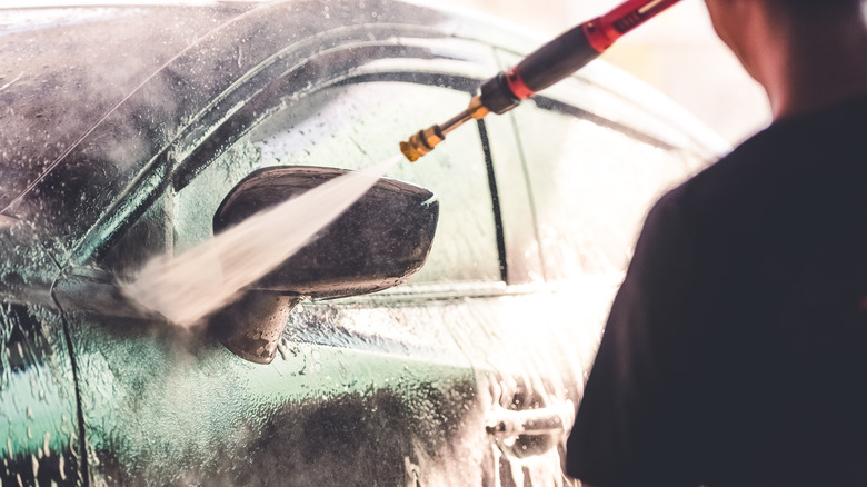 cleaning car with pressure washer