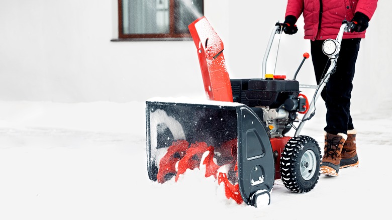 motorized snowblower getting pushed through the snow