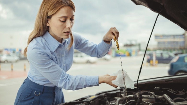 person checking engine oil