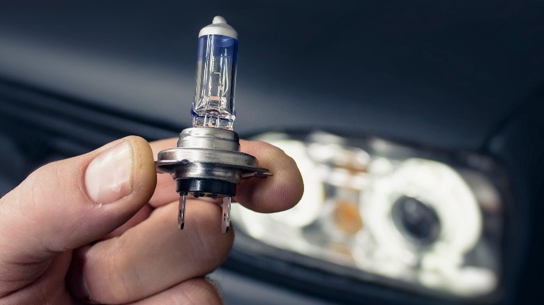 person holding car headlight bulb