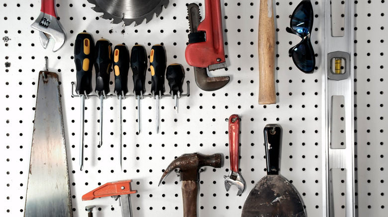 various tools hanging on pegboard wall