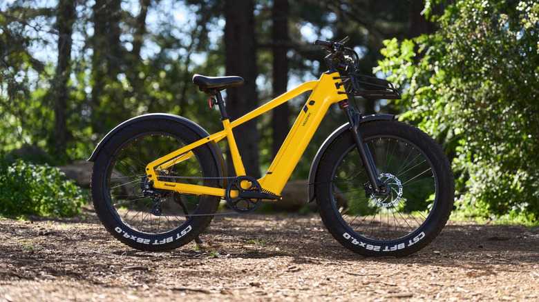 A yellow offroad e-bike parked outdoors.