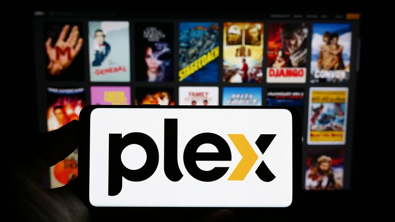 Plex logo on phone in front of TV