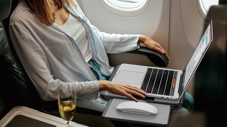 Woman using lap desk on airplane