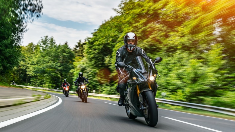 People driving motorcycle on winding road