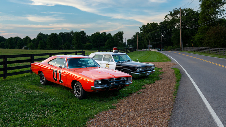 Replicas of the General Lee and Sheriffs car, from the television series The Dukes of Hazzard, parked along a road in Tennessee.