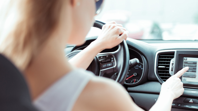 Woman using touch menu driving