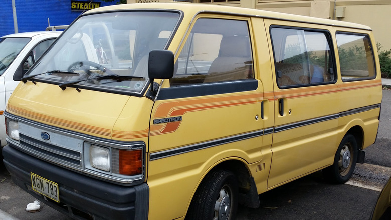 Old yellow Ford Spectron with orange detail parked