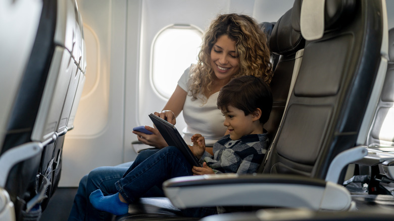 mother and child using tablet on commercial flight