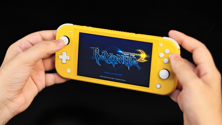 two hands holding yellow Nintendo Switch Lite