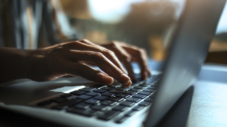 person typing on laptop keyboard