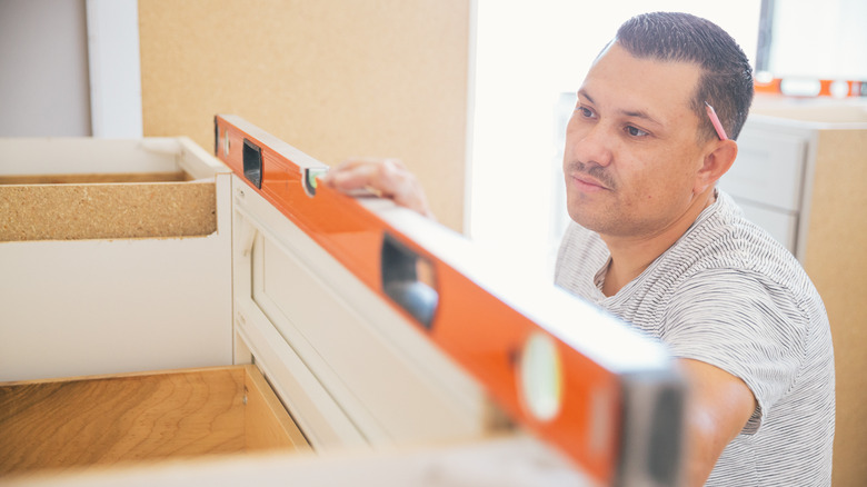 Man leveling cabinets