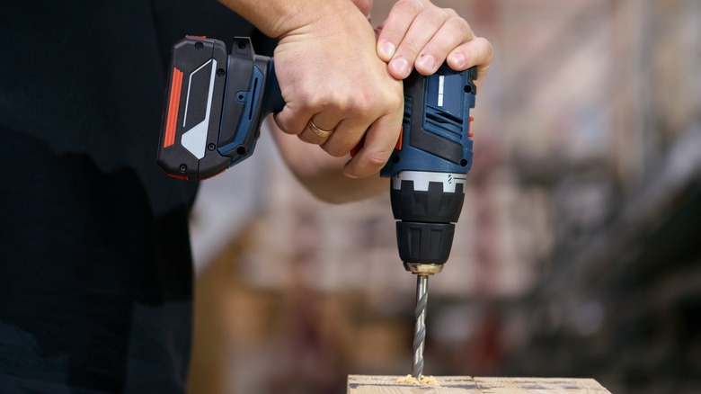 A person using a cordless drill.