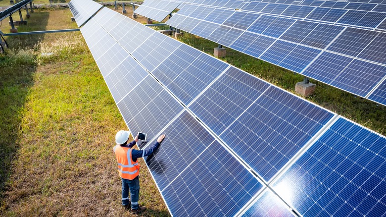 worker look at solar panels