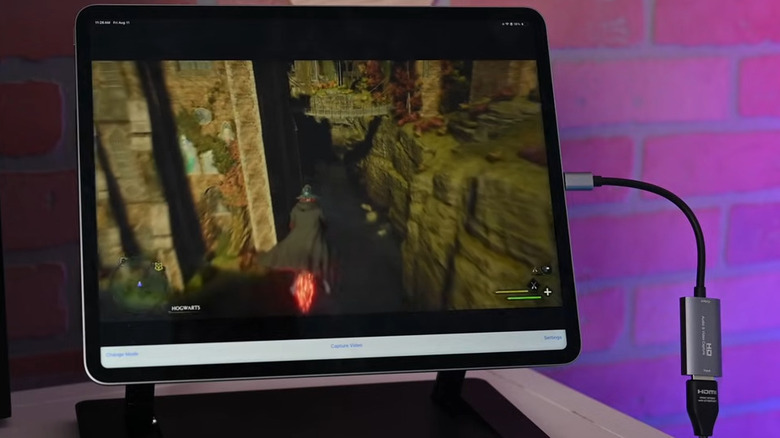 iPad on a desk running PS5 game with capture card connected