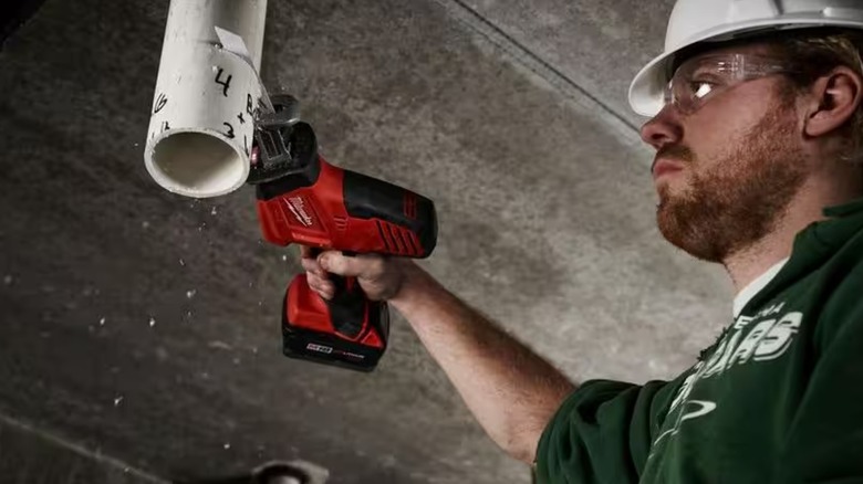 Worker using Milwaukee M18 Hackzall on PVC pipe