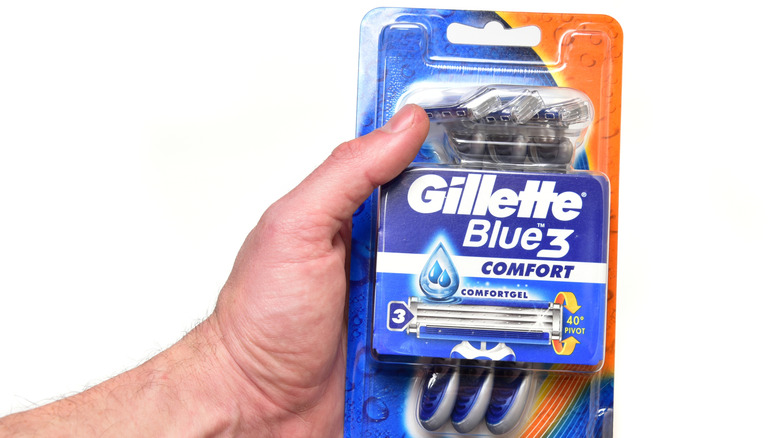 Hand holding blister pack of Gilelette razors