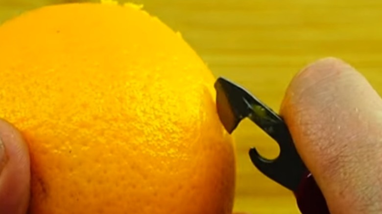 Peeling an orange with a Swiss Army Knife can opener