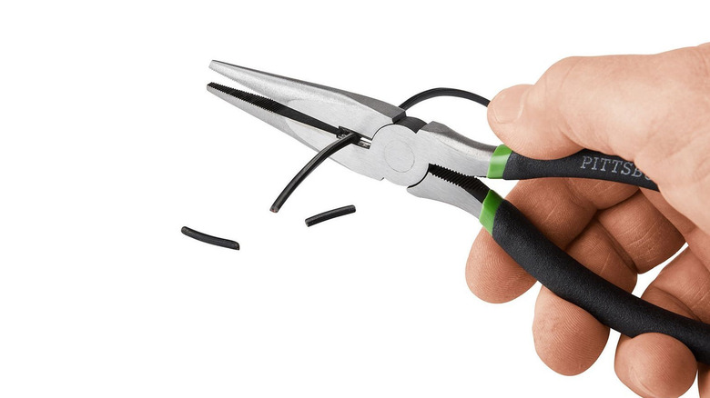 person cutting wire with pliers