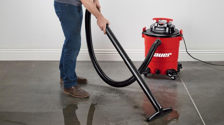 Person vacuuming water off floor