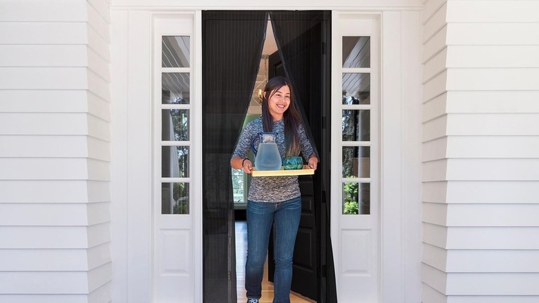 Woman walking through Harbor Freight screen door