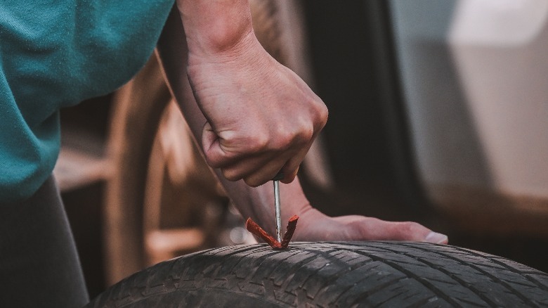 Person fixing flat tire with repair cords