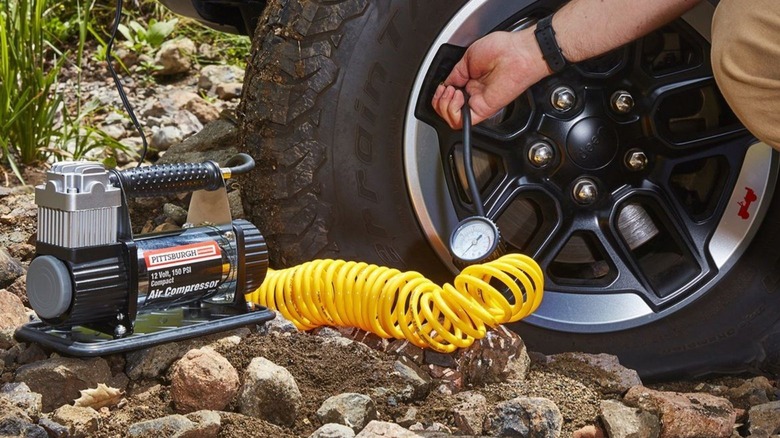 Person using a tire inflator on tire