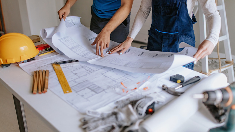 two people going over construction blueprints 