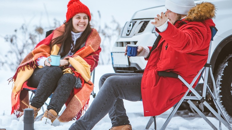 Man and woman sitting outside in the snow