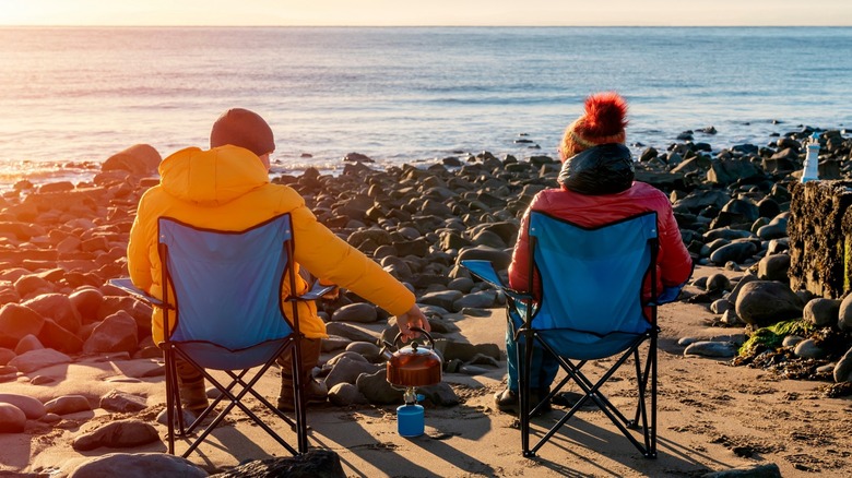 Two people sitting on chair at the beach