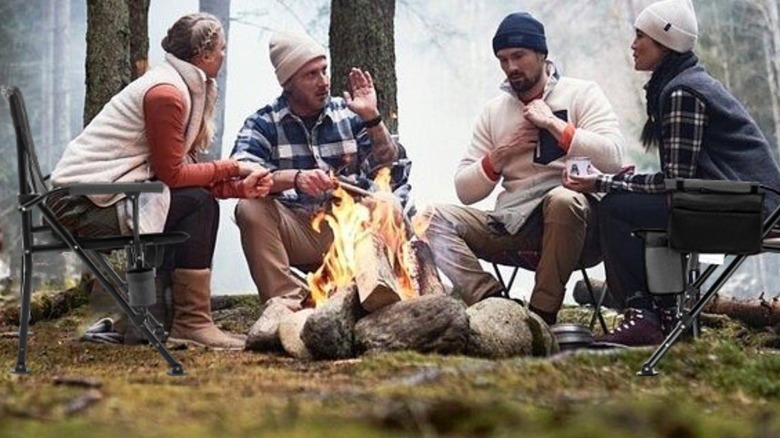 People sitting in chairs around a fire