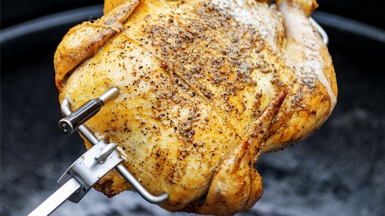 A rotisserie chicken with a thermometter in it