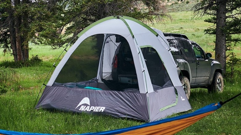 Tent and SUV in woods with hammock up