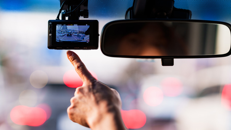 driver's finger pointing at dash cam