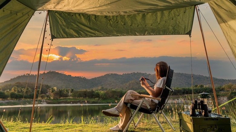 Person in tent looking at sunset