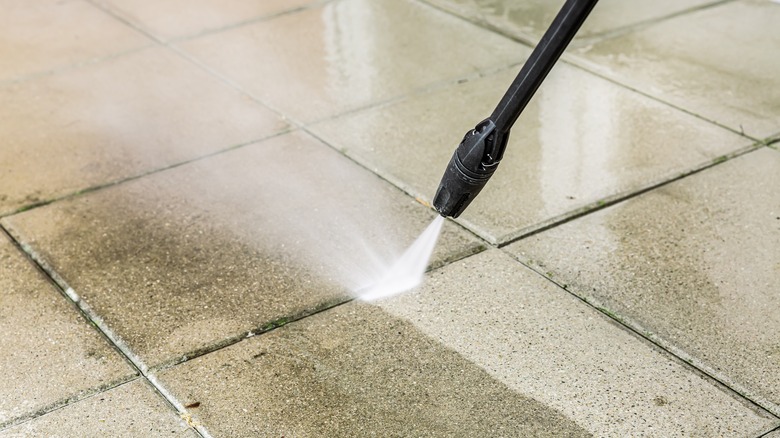 Person pressure washing walkway