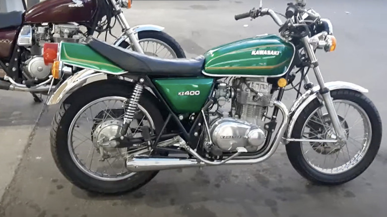 Green Kaweasaki KZ400  parked in garage with oil stains on floor