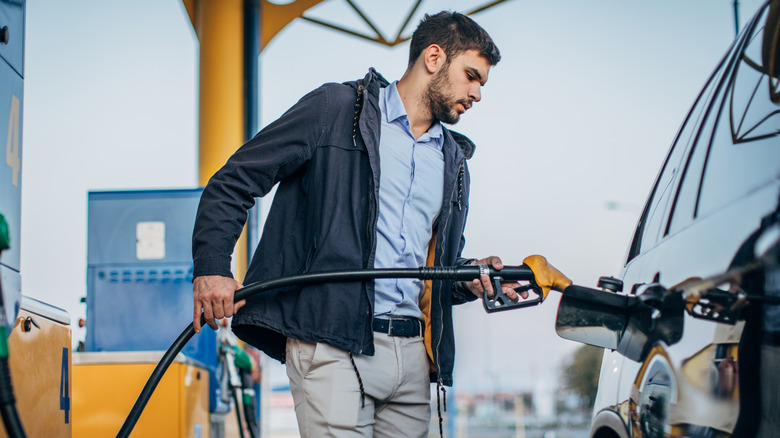 man pumping gas into vehicle